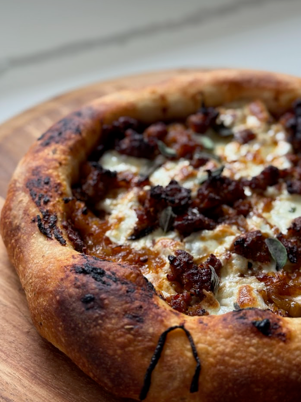 Close-up of a pizza with toppings on a wooden board